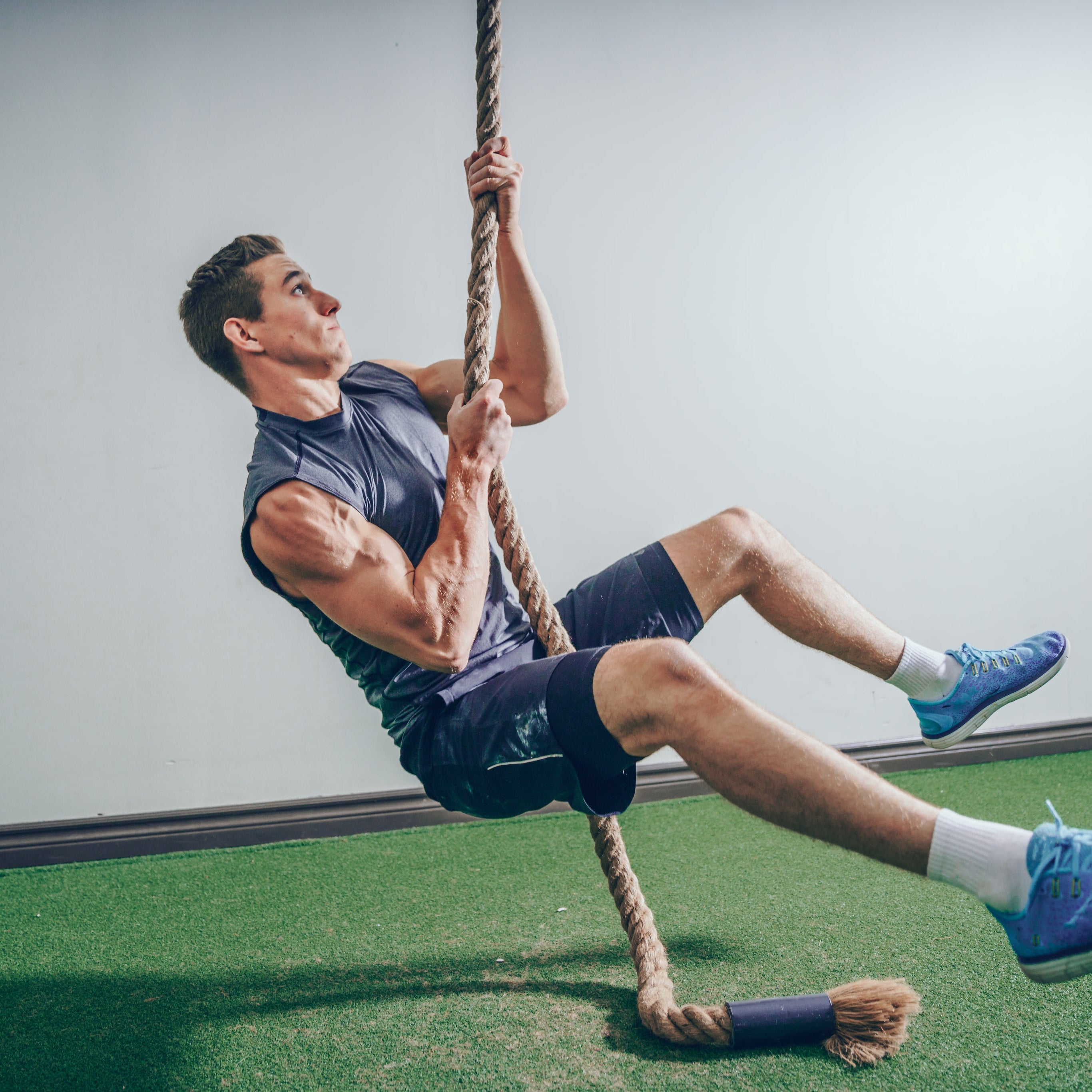 Guy climbing a rope with his arms