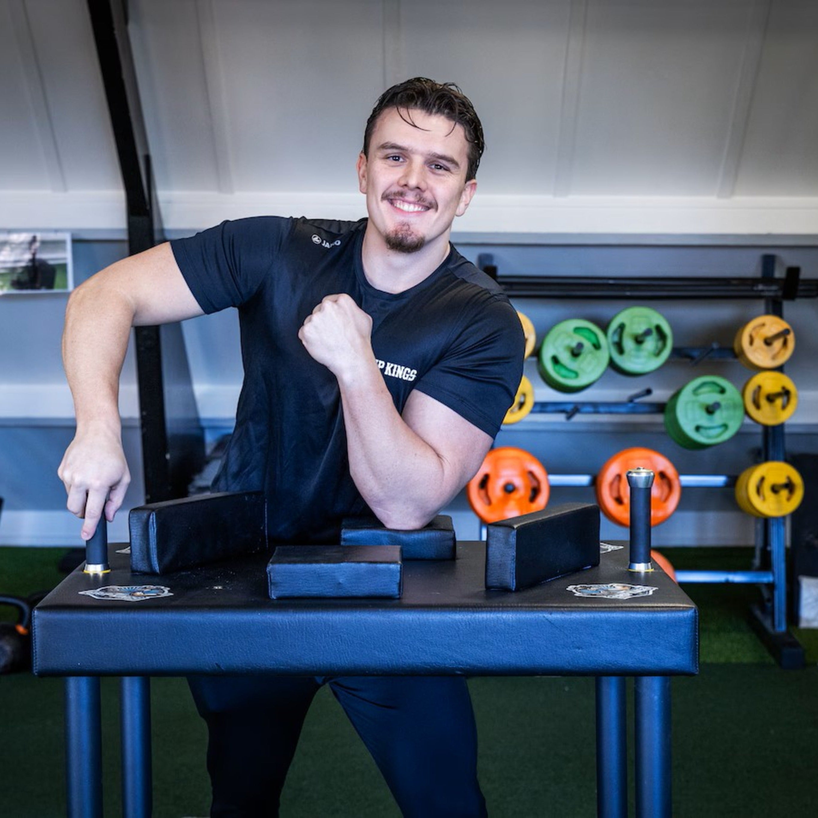 Man posing with his armwrestling table from Grip Kings